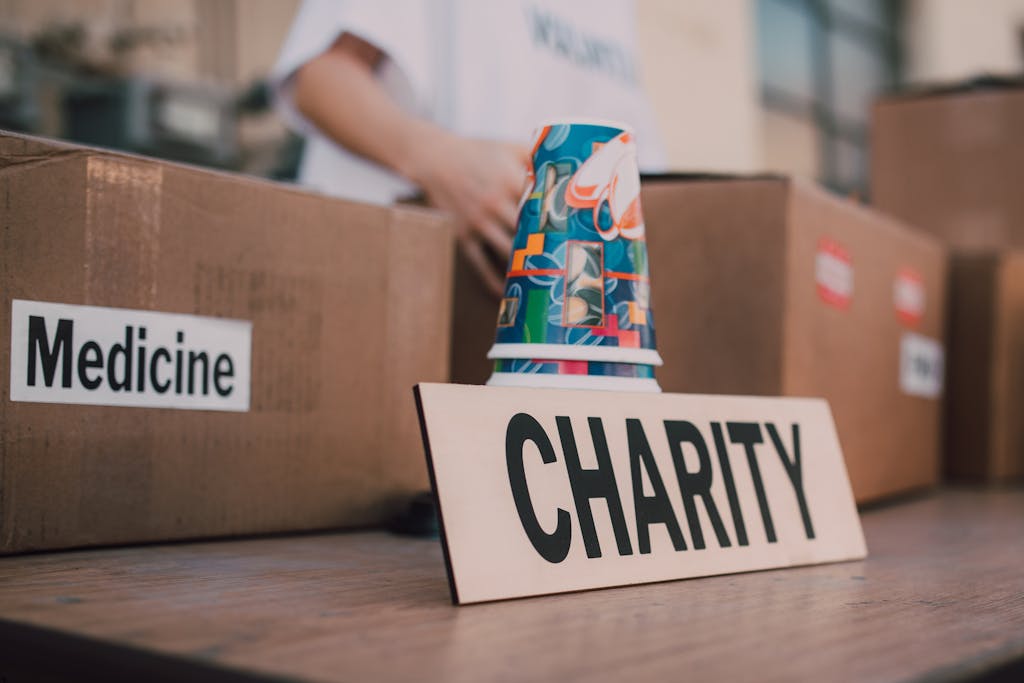 Close-up of charity boxes labeled for donation, featuring medicine and colorful paper cups.